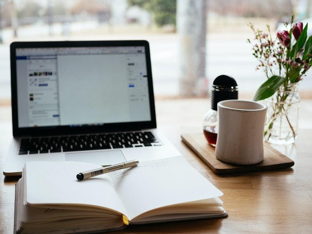 10 Effective Blog Writing Tips that you Must Know 1 Copy and pen in front of a laptop